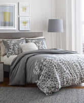 A gray and white bed featuring a soft gray comforter, neatly arranged for a cozy appearance.